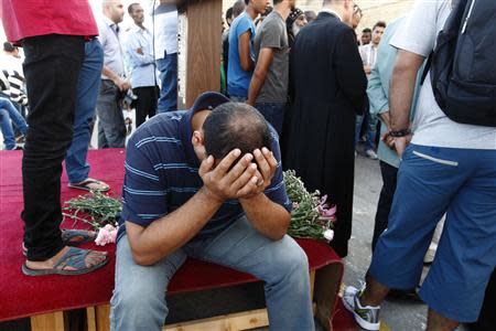 A Syrian migrant whose children drowned earlier this month buries his head in his hands, during a commemorative service organised by the Jesuit Refugee Services for immigrants who lost their lives at sea earlier this month, at Valletta's Grand Harbour, October 25, 2013. REUTERS/Darrin Zammit Lupi