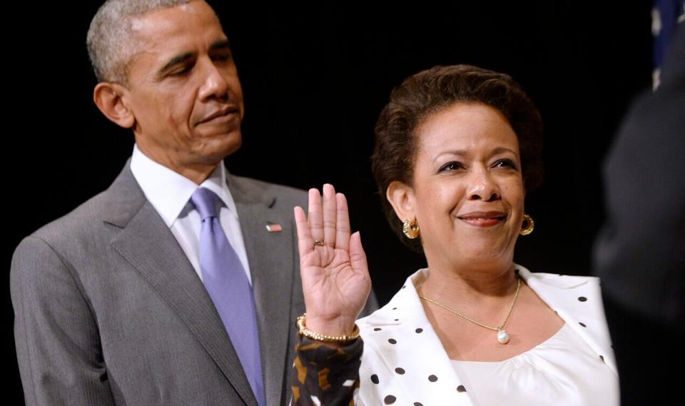 Attorney General Loretta Lynch (R) is sworn in during a formal investiture ceremony as U.S. President Barack Obama looks on at the Warner Theatre June 17, 2015 in Washington, DC. Lynch was officially sworn in by Vice President Joe Biden as the 83rd Attorney General of the United States on April 27, 2015. She is the first African-American woman to serve in the position. (Photo by Olivier Douliery – Pool/Getty Images)