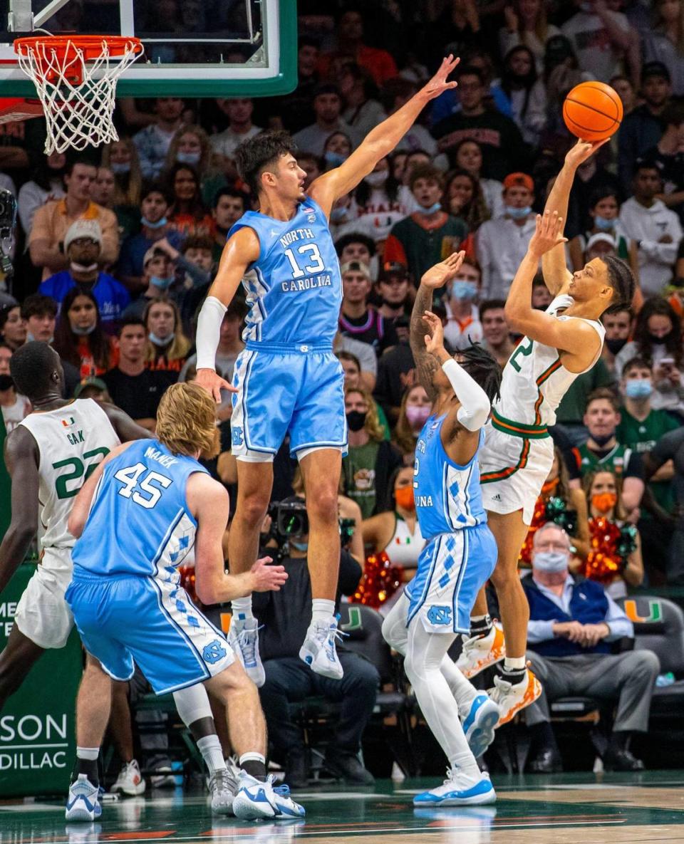 University of Miami point guard Isaiah Wong (2) shoots the ball while defended by University of North Carolina forward Dawson Garcia (13) during the second half of an NCAA basketball game at the Watsco Center in Coral Gables, Florida, on Tuesday, January 18, 2022.