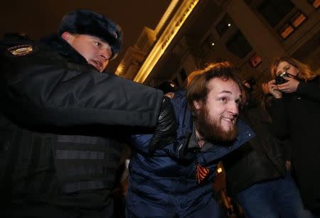 A policeman detains a protester in Moscow January 15, 2015. REUTERS/Maxim Zmeyev