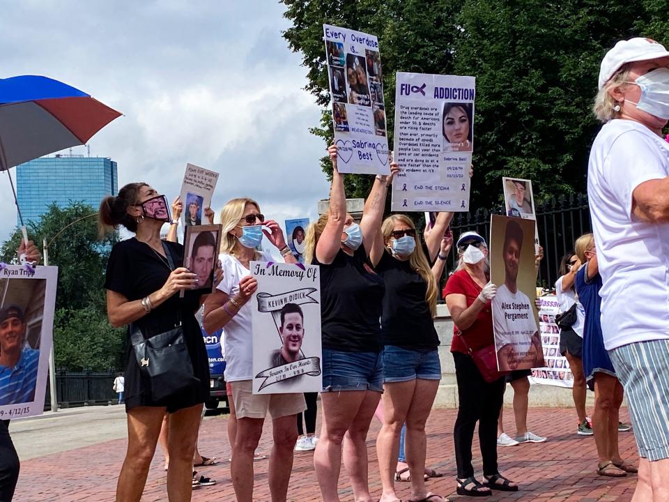 Parents who lost children to opioid overdoses stand outside the State House urging Gov. Charlie Baker to lower flags to half-staff in honor of International Overdose Awareness Day.