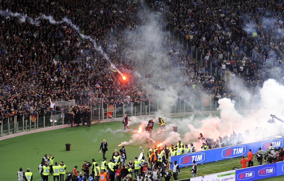 Napoli fans throw flares prior to the start of Italian Cup final match between Fiorentina and Napoli in Rome's Olympic stadium Saturday, May 3, 2014. At least one fan and one police officer were reportedly shot before the Italian Cup final between Napoli and Fiorentina, and the fan was in serious condition. As a result, the start of the final was delayed, and there were scenes of violence inside the stadium with a firefighter injured by fireworks thrown from the stands. The shootings occurred in an area where Napoli fans were gathering for the match, the ANSA news agency reported. (AP Photo/Marco Rosi, Lapresse) ITALY OUT