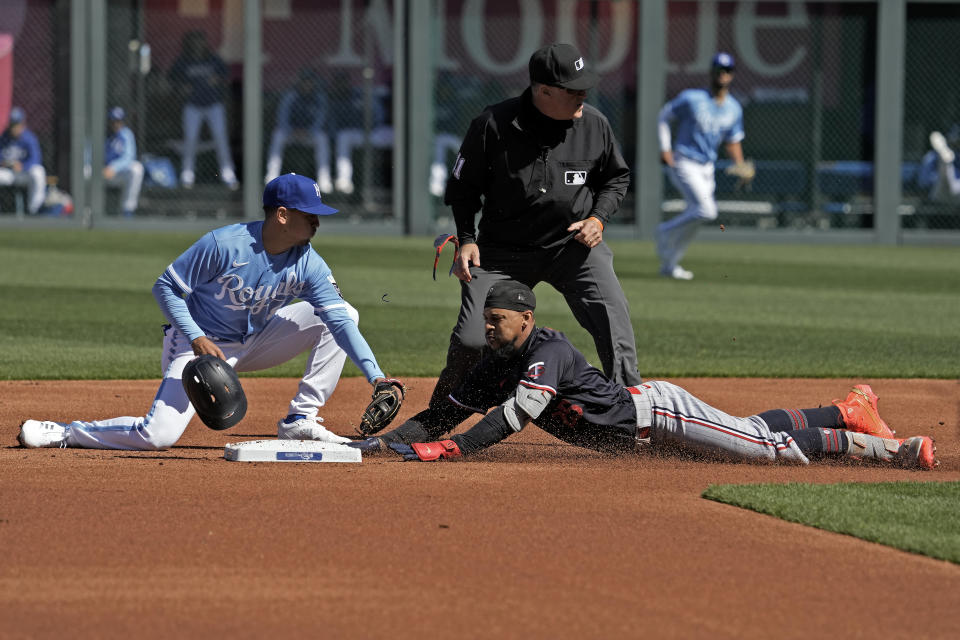 Minnesota Twins' Byron Buxton, right, beats the tag by Kansas City Royals second baseman Nicky Lopez after hitting a double during the first inning of a baseball game Saturday, April 1, 2023, in Kansas City, Mo. (AP Photo/Charlie Riedel)