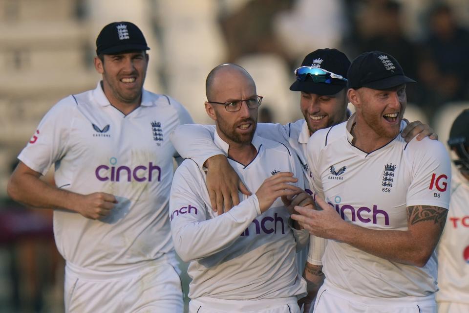 England's Jack Leach, center, celebrates with teammates after taking the wicket of Pakistan's Imam-ul-Haq during the third day of the second test cricket match between Pakistan and England, in Multan, Pakistan, Sunday, Dec. 11, 2022. (AP Photo/Anjum Naveed)