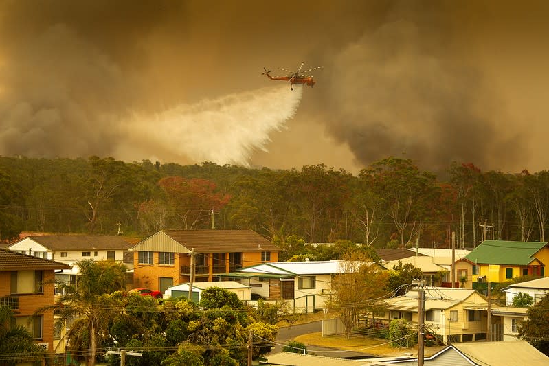 An Aircrane water bombing helicopter drops water on a bushfire in Harrington