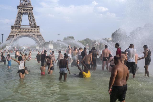 People cool down in the fountains of the Trocadero gardens in Paris, Thursday July 25, 2019, when a new all-time high temperature of 42.6 degrees Celsius (108.7 F) hit the French capital. in the background is the Eiffel Tower. (AP Photo/Rafael Yaghobzadeh)
