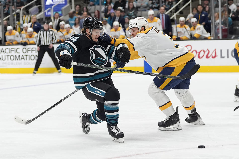 San Jose Sharks left wing Alexander Barabanov (94) moves the puck past Nashville Predators defenseman Jeremy Lauzon during the first period of an NHL hockey game Saturday, Feb. 24, 2024, in San Jose, Calif. (AP Photo/Tony Avelar)