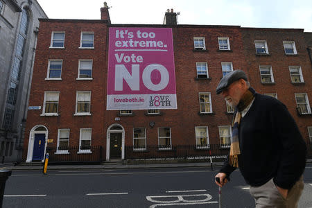 A man walks past a pro-life poster draped over buildings encouraging people to vote no ahead of a 25th May referendum on abortion law, in Dublin, Ireland May 22, 2018. REUTERS/Clodagh Kilcoyne