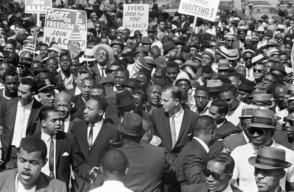 In this June 23, 1963, file photo, Martin Luther King Jr. joins Detroit's Freedom March. The massive crowd was peaceful but impossible to contain, and King, lower left, did not lead the march. During the crucial era of the 1950s and '60s, King, who led the 250,000-strong March on Washington in 1963, and Malcolm X were colossal 20th-century figures, representing two different tracks: mass nonviolent protest and getting favorable outcomes "by any means necessary."