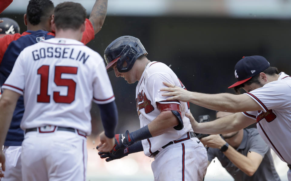 Atlanta Braves' Austin Riley, center, is mobbed by teammates after making game winning hit off Washington Nationals' Jordan Weems in the twelfth inning of a baseball game, Sunday, July 10, 2022, in Atlanta. (AP Photo/Ben Margot)