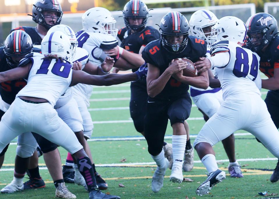 Mamaroneck's Jason Cox (5) looks for some running room in the New Rochelle defense during football action at Mamaroneck High School Oct. 14, 2022. 