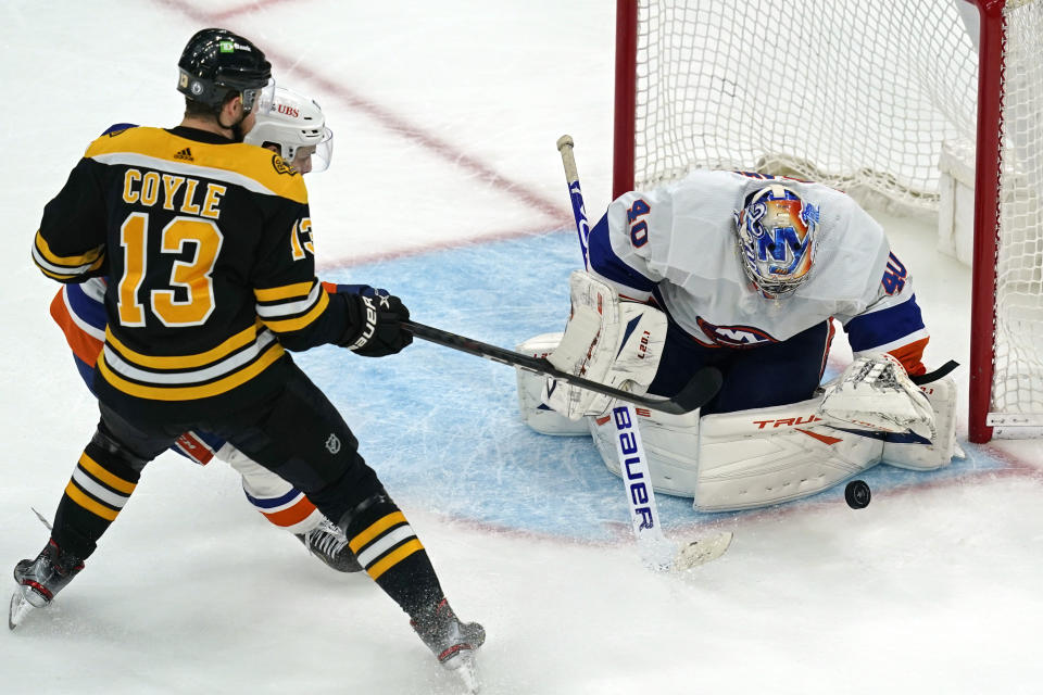 New York Islanders goaltender Semyon Varlamov (40) keeps the puck in front as Boston Bruins center Charlie Coyle (13) is defended by Islanders center Mathew Barzal during the third period of Game 5 of an NHL hockey second-round playoff series, Monday, June 7, 2021, in Boston. (AP Photo/Elise Amendola)