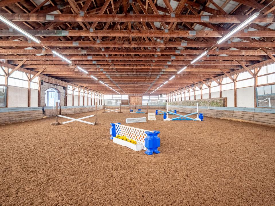 An indoor horse riding area inside the equestrian facility.