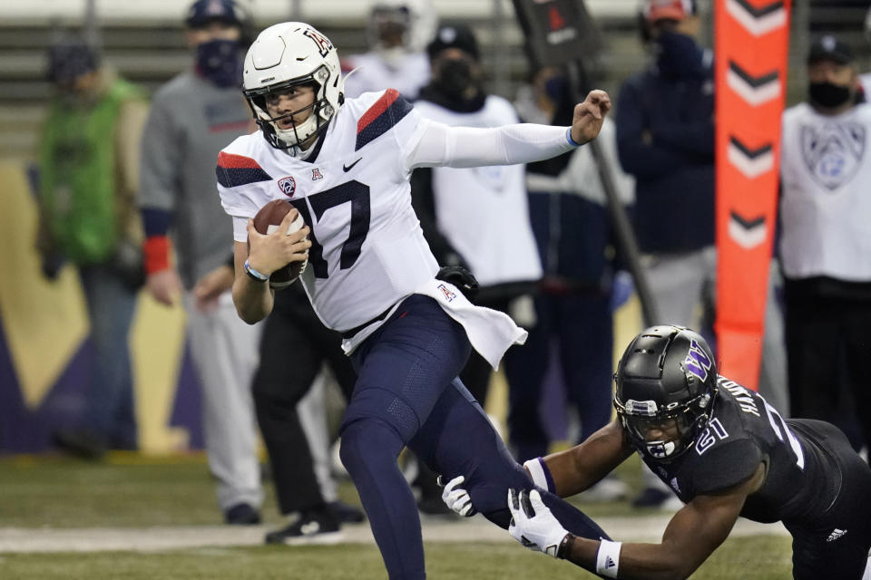 Arizona quarterback Grant Gunnell (17) is tripped by Washington's Dominique Hampton during the second half of an NCAA college football game Saturday, Nov. 21, 2020, in Seattle. Washington won 44-27. (AP Photo/Elaine Thompson)