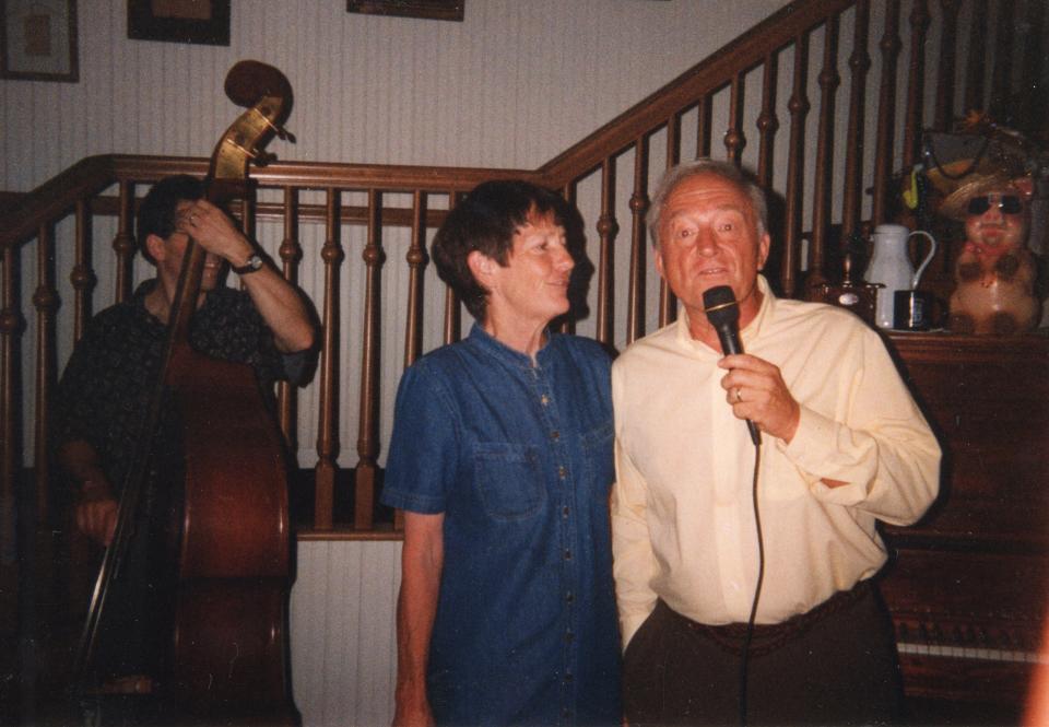 Walt and Martha Dear take the microphone to sing at Planter’s Coffee House sometimes in the 1990s while musician Michael Grey performs the standup bass in the background. Walt Dear loved music and was both a patron of professional musical presentations and an eager performer. (Photo courtesy of Connie Walaskay)