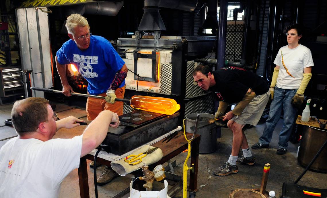 Stephen Rolfe Powell (standing and wearing a blue shirt), an internationally-known artist and Centre College professor, works in his studio in a file photo.