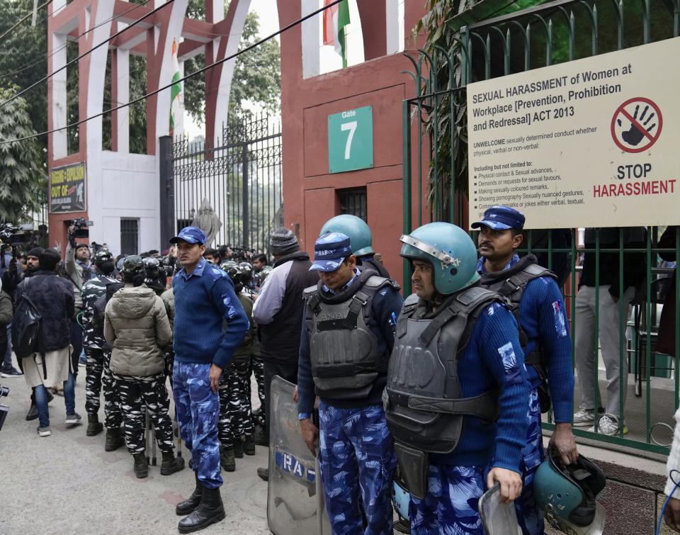 Security personnel guard the main gate of Jamia Millia Islamia university in New Delhi, India, Wednesday, Jan. 25, 2023. Tensions escalated in the university after a student group said it planned to screen a banned documentary that examines Indian Prime Minister Narendra Modi's role during 2002 anti-Muslim riots, prompting dozens of police equipped with tear gas and riot gear to gather outside campus gates. (AP Photo/Manish Swarup)