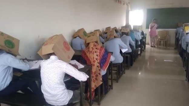 Pupils were forced to wear cardboard boxes on their heads in a bid to stop them cheating during a chemistry exam at Bhagat Pre-University College in Haveri, Karnataka state. (Twitter/BBC)