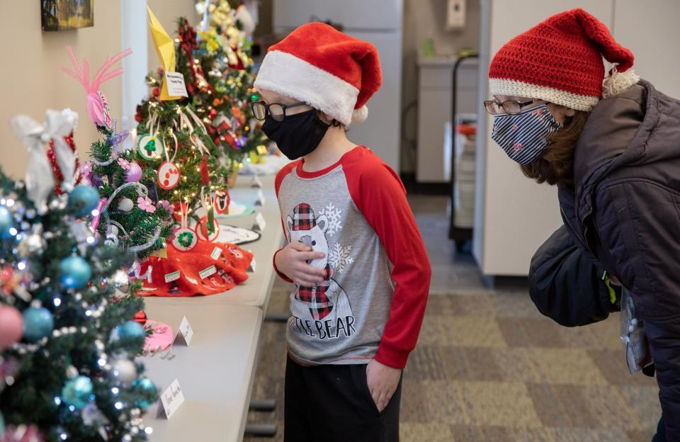 Christopher Hobbs, 8, and his mom, Lyndsay Smeyres, look at the mini Christmas tree competition during the Christmas on the Canal celebration Saturday, Dec. 4, 2021. The event featured several activities including the contest featuring small Christmas trees decked out for the season.