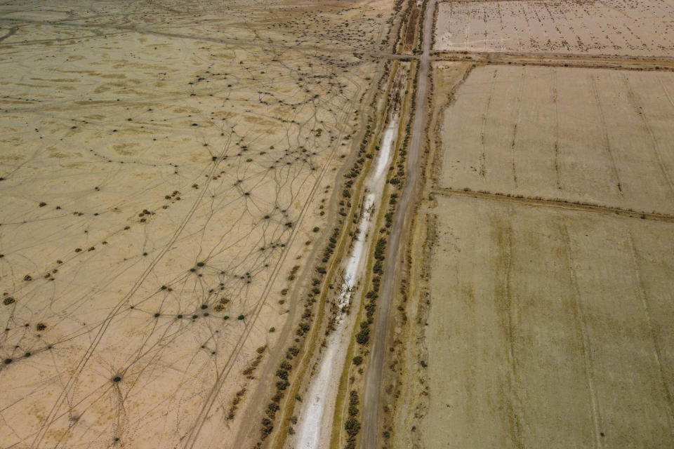 The irrigation channel in the district of Dawwayeh is dry due to low water levels as a result of back to back drought and severe cuts by the Iraqi government. Farmers have complained of widespread crop failure and many have left their lands for the cities, in Dhi Qar province, Iraq, Sept. 3, 2022. (AP Photo/Anmar Khalil).