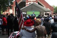 <p>Mourners watched the funeral from an overflow area outside the church. One woman held and American flag while watching President Obama give his eulogy. </p>