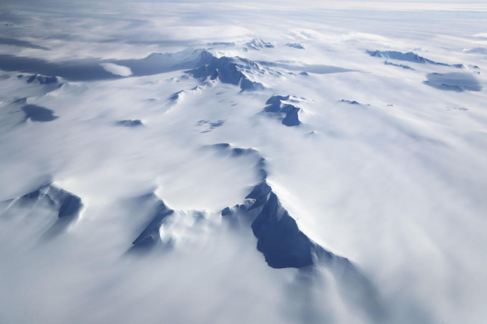 <p>Mountains peek through land ice, as seen from NASA’s Operation IceBridge research aircraft in the Antarctic Peninsula region on Nov. 4, 2017, above Antarctica. (Photo: Mario Tama/Getty Images) </p>