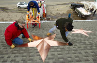 Greg Gnandt (I) y Guy Veneruso instalan 26 estrellas en el techo de la estación de bomberos aledaña a la escuela Sandy Hook, este 1 de enero de 2013, en Newtown, Connecticut, en memoria de las 26 víctimas de la masacre del 14 de diciembre pasado. AP Photo/The News-Times, Brett Coomer