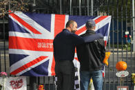 INDIANAPOLIS, IN - OCTOBER 17: Drew Boyd (L) comforts Nick Garside after the two hung a Union Jack as a tribute to two-time Indianapolis 500 winner Dan Wheldon at a memorial at the gate of the Indianapolis Motor Speedway on October 17, 2011 in Indianapolis, Indiana. Wheldon, winner of the 2011 Indy 500, was killed in a crash yesterday at the Izod IndyCar series season finale at Las Vegas Motor Speedway. "Dan was special. He was our hero", said Garside, who was originally from Yorkshire, England, after hanging the flag. (Photo by Scott Olson/Getty Images)