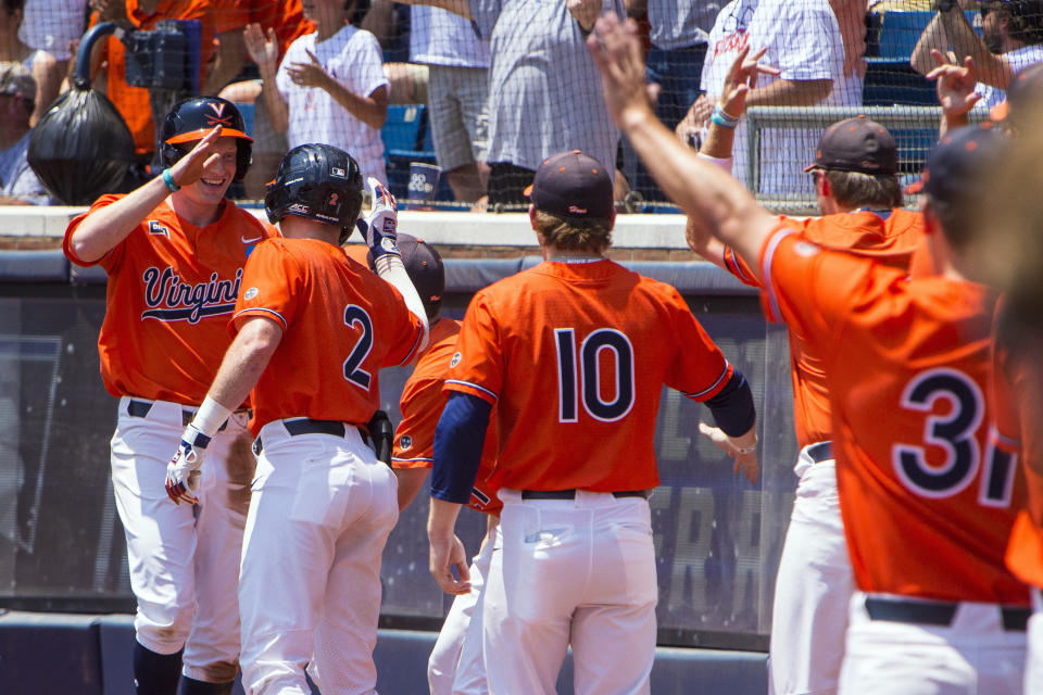 Virginia's Casey Saucke, left, celebrates with his teammates after being batted in by teammate Henry Godbout in the second inning against Duke in Game 2 of an NCAA college baseball tournament super regional game, Saturday, June 10, 2023, in Charlottesville, Va. (AP Photo/John C. Clark)