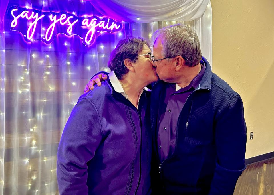 Shari and Richard Cathcart of Edmond kiss near a special backdrop at Acts 2 United Methodist Church, where an Ash Wednesday service included a wedding vow renewal ceremony as a nod to the convergence of Valentine's Day with the religious observance marking the beginning of Lent. [Carla Hinton]