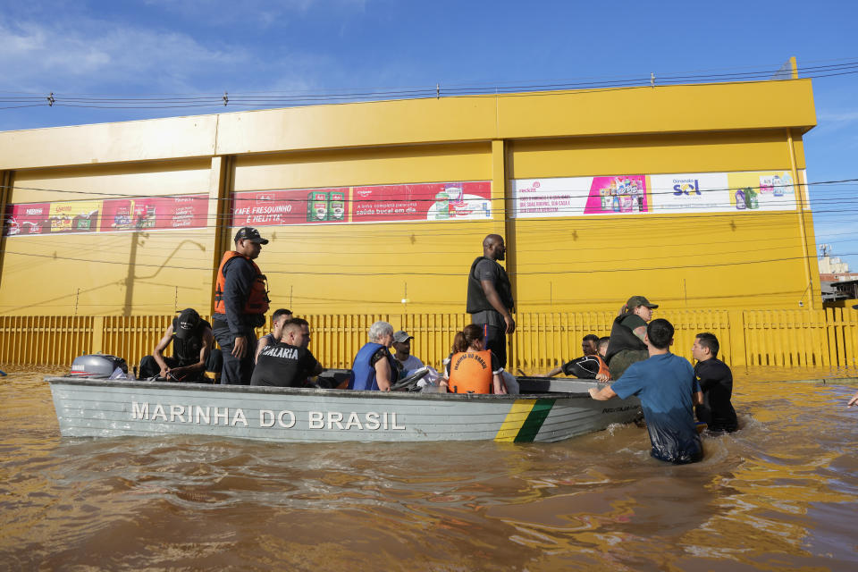 Volunteers evacuate residents from an area flooded by heavy rains, in Porto Alegre, Brazil, Tuesday, May 7, 2024. (AP Photo/Andre Penner)