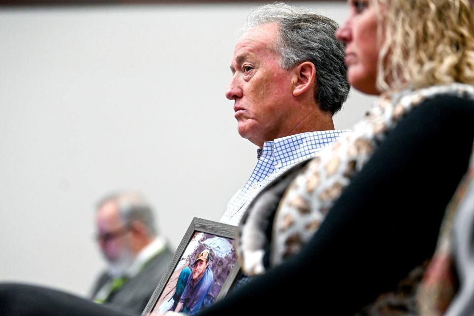 Thomas Small, left, holds a picture of his son Joseph during the trial on Monday, April 4, 2022, in Ingham County Circuit Court Judge Clinton Canady III's courtroom in Lansing for the man charged with selling drugs to his son before his death.