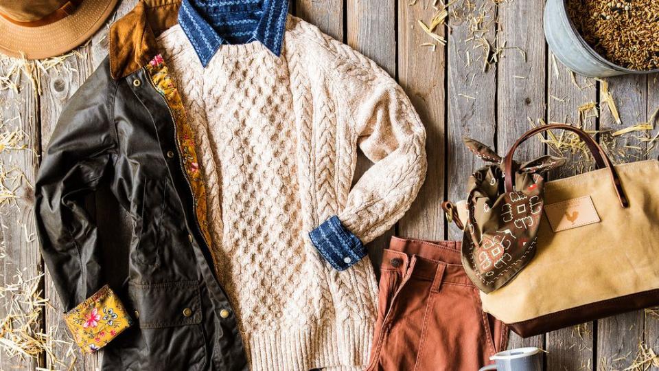 ivory fishermans sweater layered with other fall pieces including boots and a waxed canvas barn coat