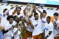 Texas celebrates and holds the trophy for the NCAA college basketball game championship of the Maui Invitational after they beat North Carolina 69-67, Wednesday, Dec. 2, 2020, in Asheville, N.C. (AP Photo/Kathy Kmonicek)