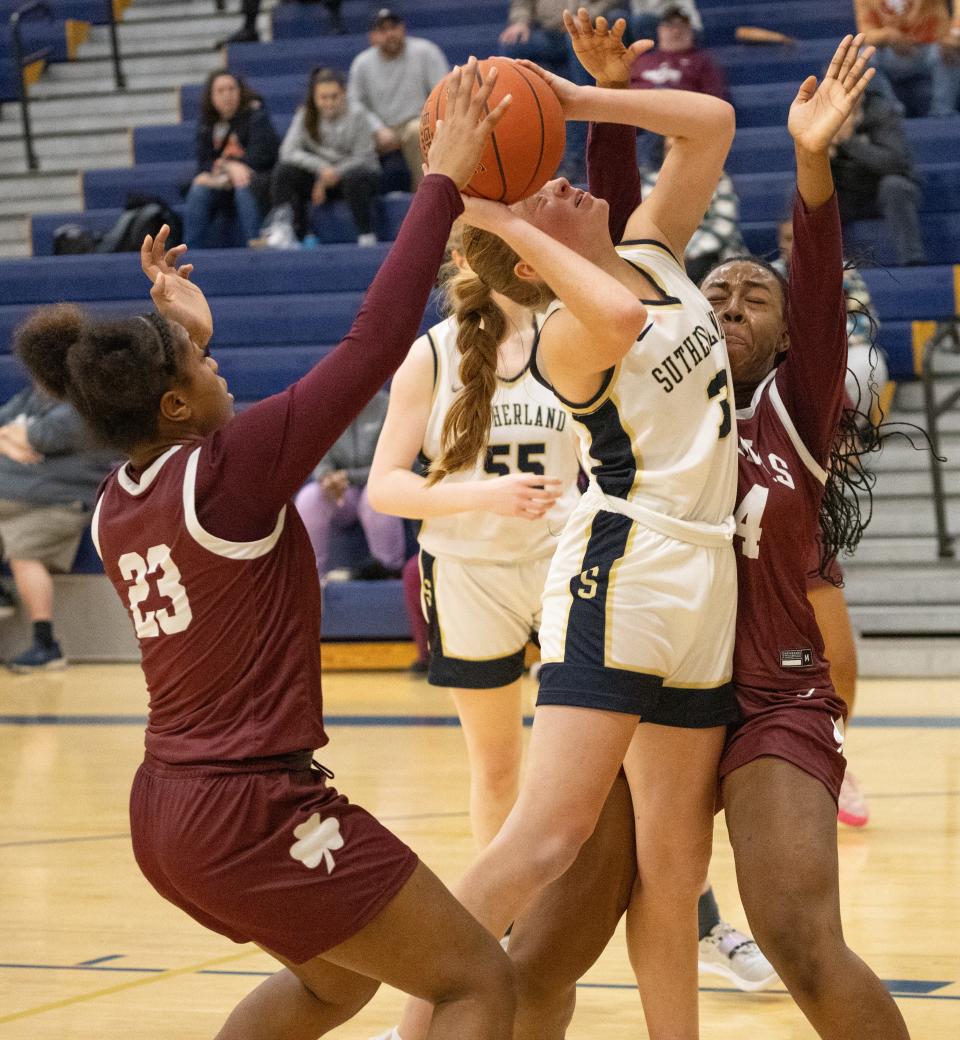 Pittsford Sutherland's Leora Cook tries to shoot while Aquinas' Jade Harvey, left, and Samiyah Wright defend.