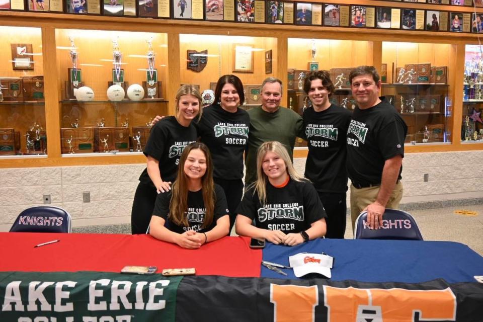 Kali Woods sits with her sister Kenzie and the rest of her athletic family as Maddie (far left) and Cael (second from right) to celebrate her signing to Lake Erie College.