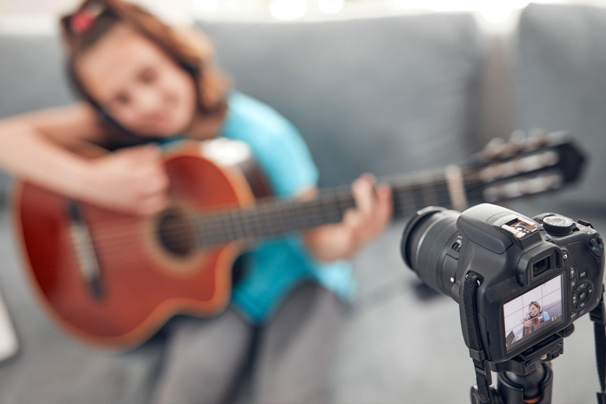 Child guitarist making video lessons and tutorials for internet vlog Getty Images/m-gucci