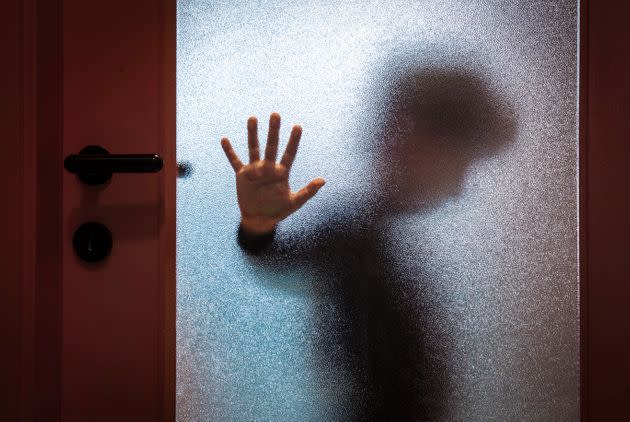 Blurred sad boy leaning open hand against glass door. (Photo: RinoCdZ via Getty Images)