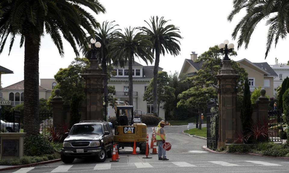 A construction workers stands in front of the Presidio Terrace, a gated community in San Francisco.