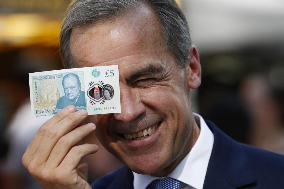 LONDON, UNITED KINGDOM – SEPTEMBER 13: Bank of England governor Mark Carney poses with a new polymer five pound note at Whitecross Street Market on September 13, 2016 in London, United Kingdom. The new plastic note is designed to be more durable and features a portrait of former British Prime Minister Sir Winston Churchill. (Photo by Stefan Wermuth – WPA Pool/Getty Images)