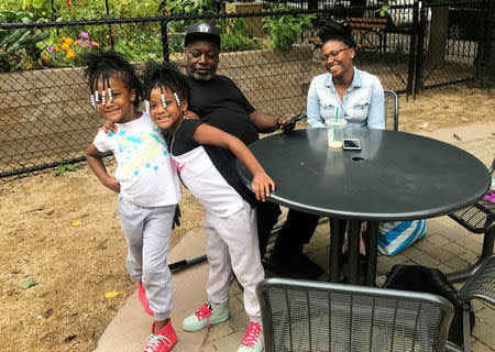 Six-year-old twins Kaitlyn and Chasity Ellis, who were exposed to lead in a Brooklyn apartment, pose with their mother Barbara Ellis (R) and grandfather Ruden Ellis in a park in Harlem - where the family now lives - in New York City, U.S. September 20, 2017. REUTERS/Joshua Schneyer/Files