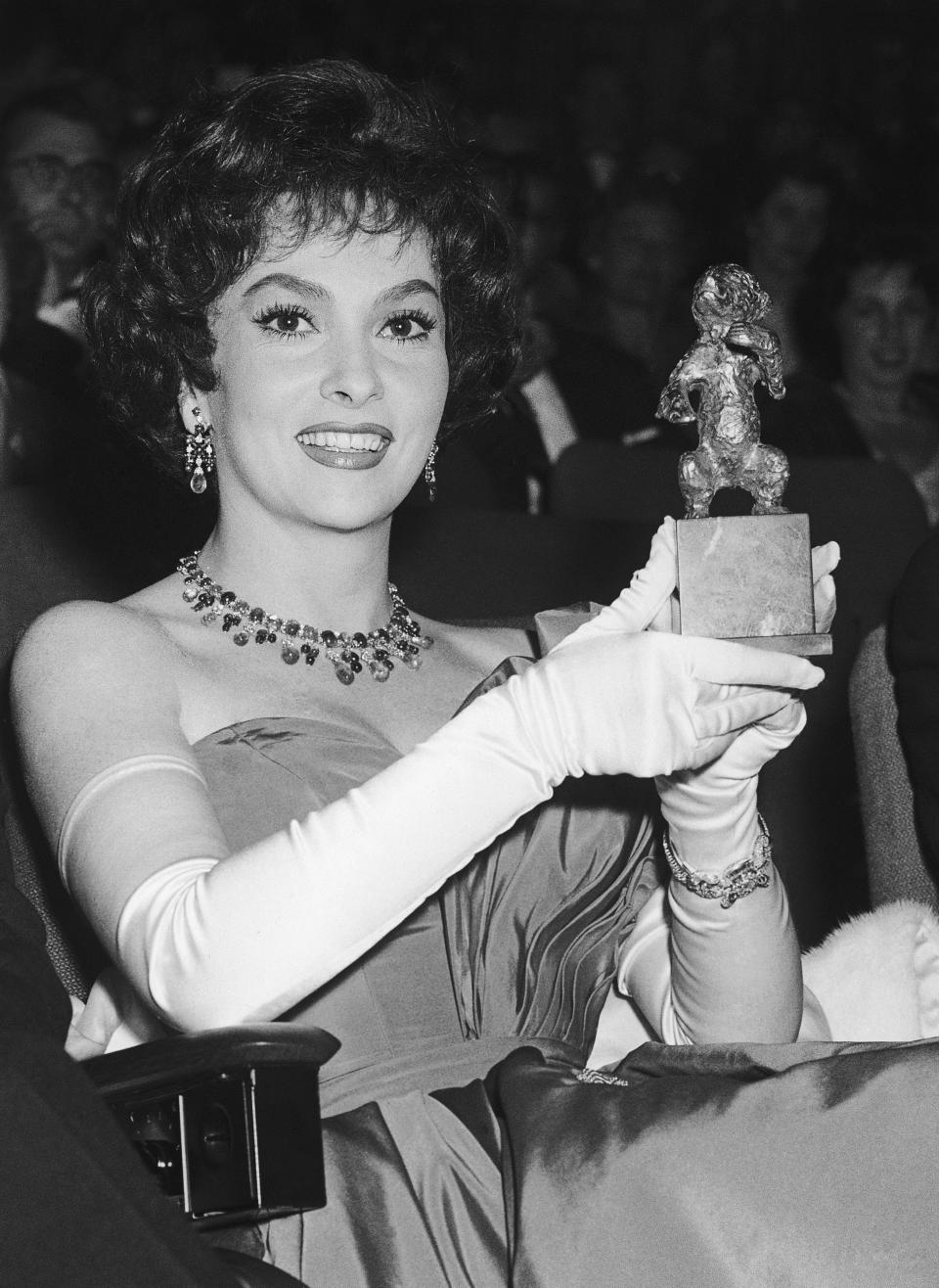 ARCHIVO - La actriz italiana Gina Lollobrigida muestra el Oso de Plata que recibió a nombre de su amiga Anna Magnani durante la premiación del Festival de Cine de Berlín Occidental el 8 de julio de 1958. Lollobrigida murió en Roma a los 95 años el lunes 16 de enero de 2023, dijo su agente. (Foto AP/Heinrich Sanden Jr., archivo)