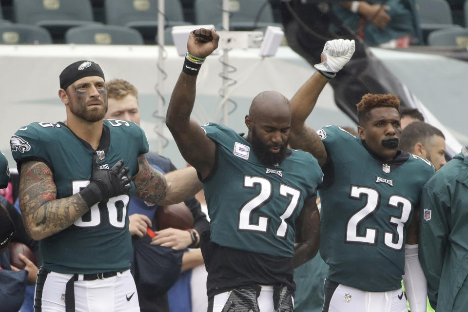 Eagles Chris Long (56), Malcolm Jenkins (27) and Rodney McLeod gesture during the national anthem on Sunday before a game against the Cardinals. (AP) 