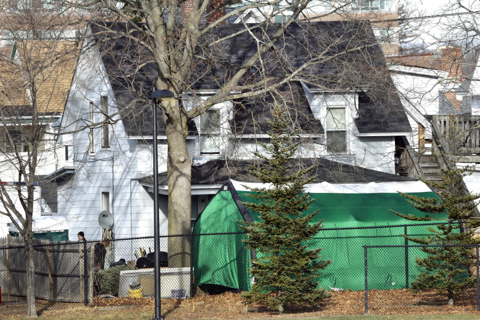 FILE - In this Jan. 17, 2017 file photo, a large green tent is seen in the back of a house on Hayward Street in Manchester, N.H., where authorities searched for clues in a missing person's case. New Hampshire authorities have identified three victims of Terry Peder Rasmussen, who is suspected of killing at least six women and children several decades ago, including his toddler daughter. Rasmussen, who used multiple names in many states, died in a California prison in 2010. (AP Photo/Elise Amendola, File)