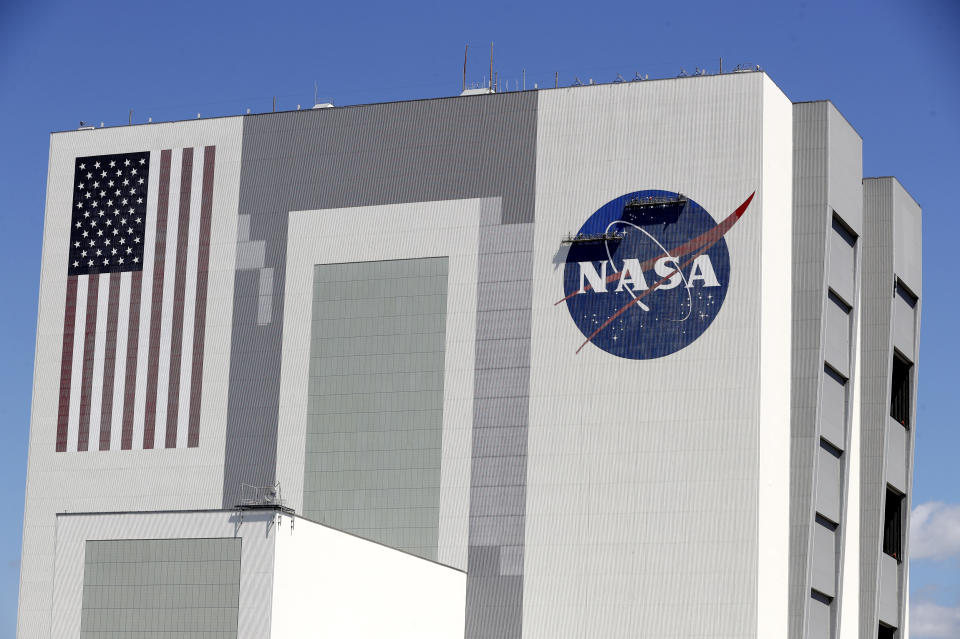 Workers near the top of the 526 ft. Vehicle Assembly Building at the Kennedy Space Center spruce up the NASA logo standing on scaffolds in Cape Canaveral, Fla., Wednesday, May 20, 2020. A SpaceX Falcon 9 rocket scheduled for May 27 will launch a Crew Dragon spacecraft on its first test flight with astronauts on-board to the International Space Station. (AP Photo/John Raoux)