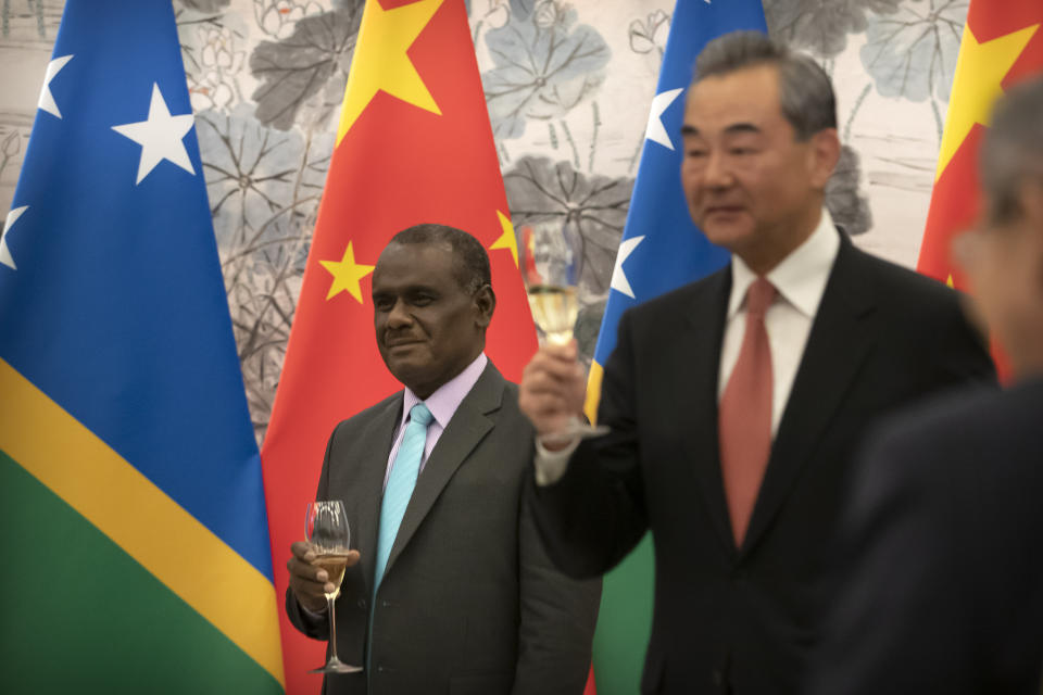 Solomon Islands Foreign Minister Jeremiah Manele, left, and Chinese Foreign Minister Wang Yi hold glasses for a toast during a ceremony to mark the establishment of diplomatic relations between the Solomon Islands and China at the Diaoyutai State Guesthouse in Beijing, Saturday, Sept. 21, 2019. (AP Photo/Mark Schiefelbein, Pool)