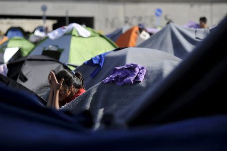 A girl washes her face at a makeshift camp for refugees and migrants at the port of Piraeus, near Athens, Greece, April 20, 2016. REUTERS/Michalis Karagiannis