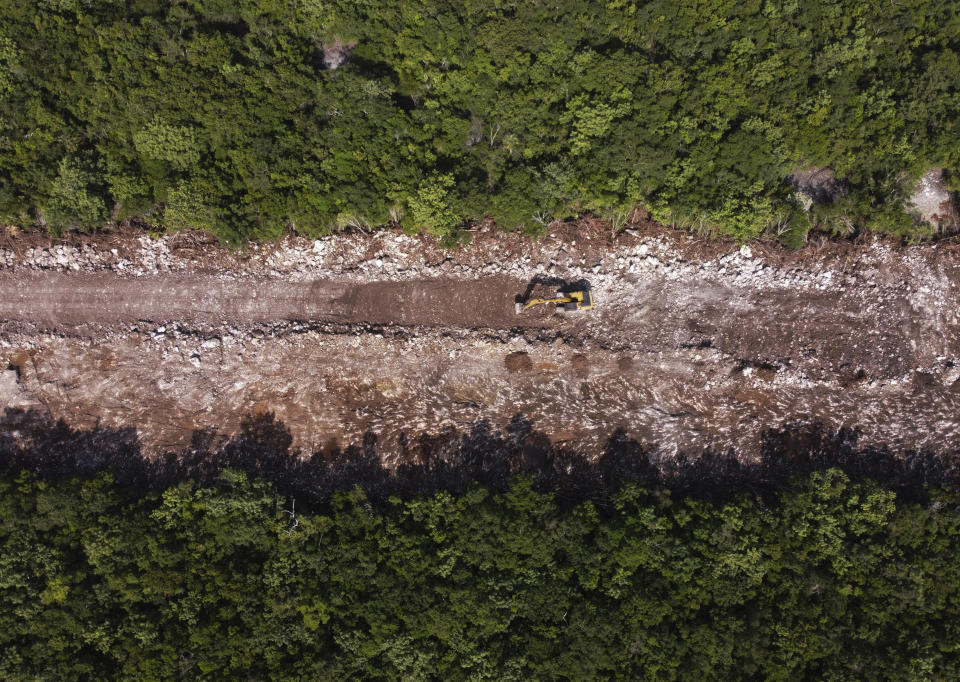 A bulldozer clears forest for the path of the Mayan Train in Puerto Morelos, Quintana Roo state, Mexico, Tuesday, Aug. 2, 2022. This stretch of the train route is controversial because it cuts a more than 68-mile (110-kilometer) swath through the jungle over some of the most complex and fragile underground cave systems in the world, between the resorts of Cancun and Tulum. (AP Photo/Eduardo Verdugo)