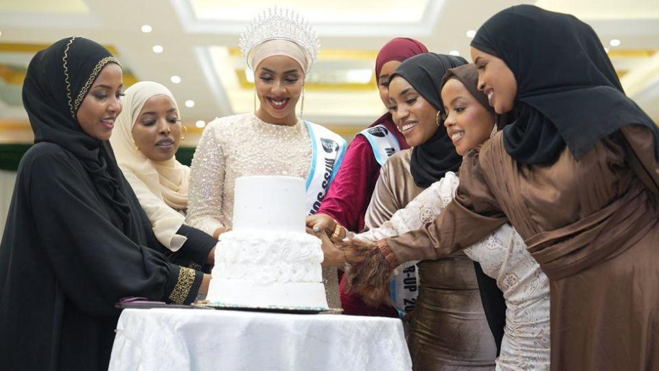 A group of women cutting a cake