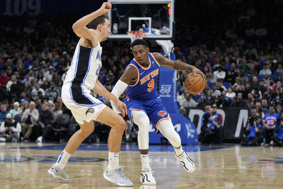 New York Knicks guard RJ Barrett (9) looks for a way around Orlando Magic forward Franz Wagner, left, during the first half of an NBA basketball game, Friday, Dec. 29, 2023, in Orlando, Fla. (AP Photo/John Raoux)